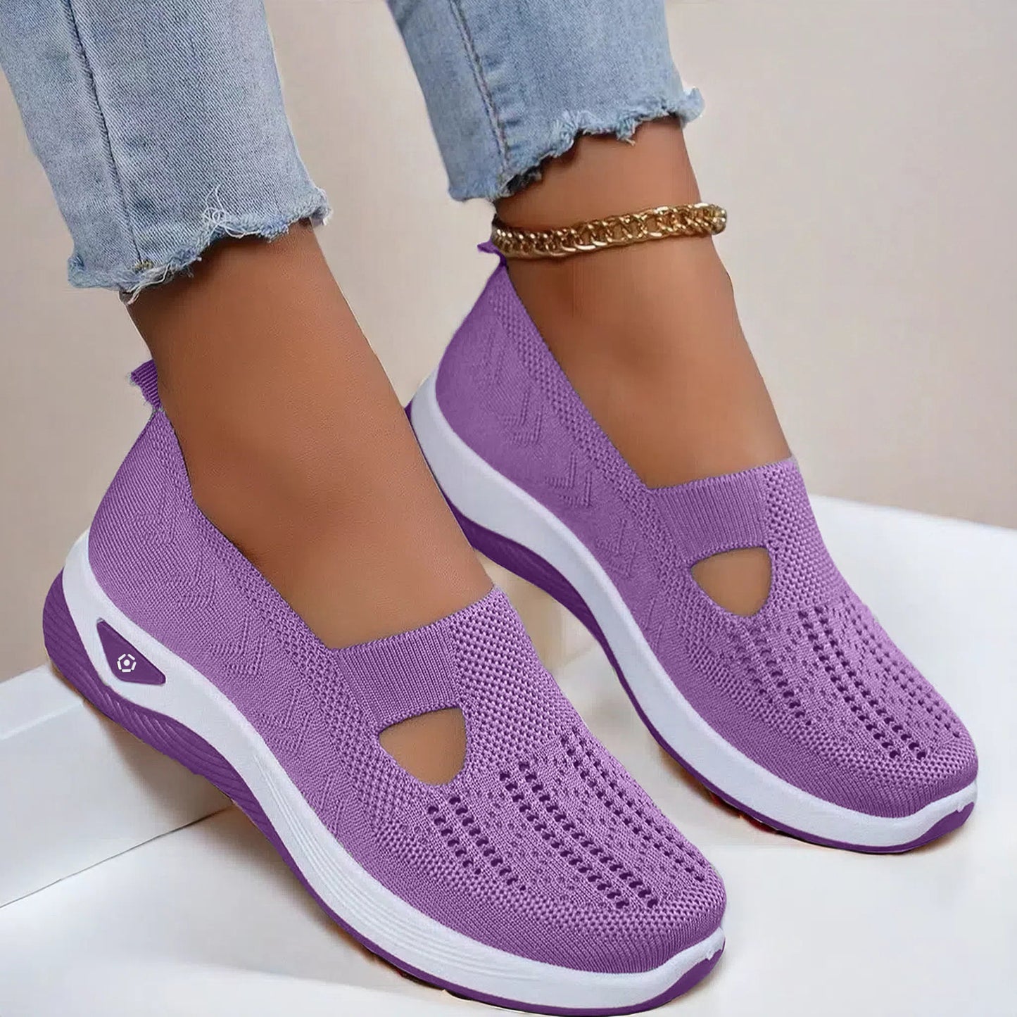 Purple slip-on shoes with white soles worn